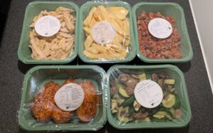 MåltidsBoxen plastbakker med madvarer på køkkenbord